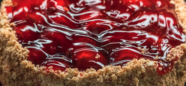 Ein Kuchen mit einem Boden aus bröseligem Teig, gefüllt mit glänzendem Tortenguss